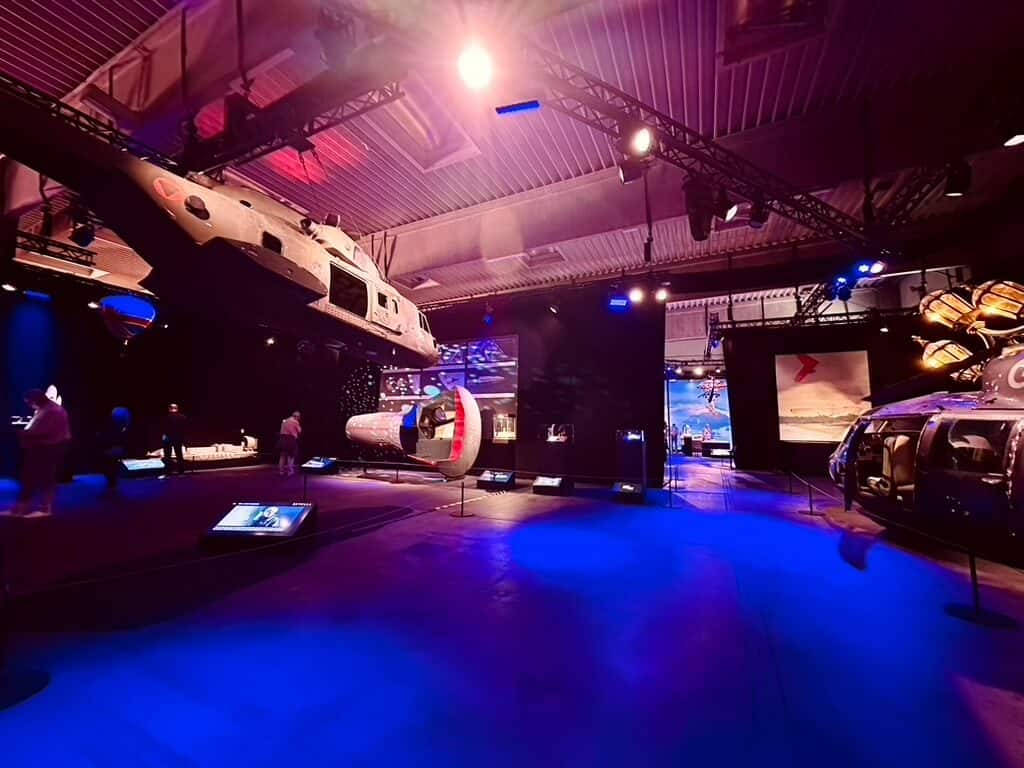 Ausstellungshalle mit Helikopter und Fahrzeugen der James Bond Filmreihe.